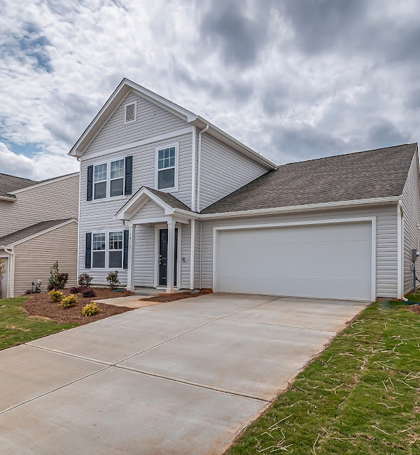 Two-car garage with light gray door on a light gray house, daytime