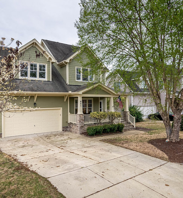 Two-car garage with tan garage door on a craftsman-style Marysville home