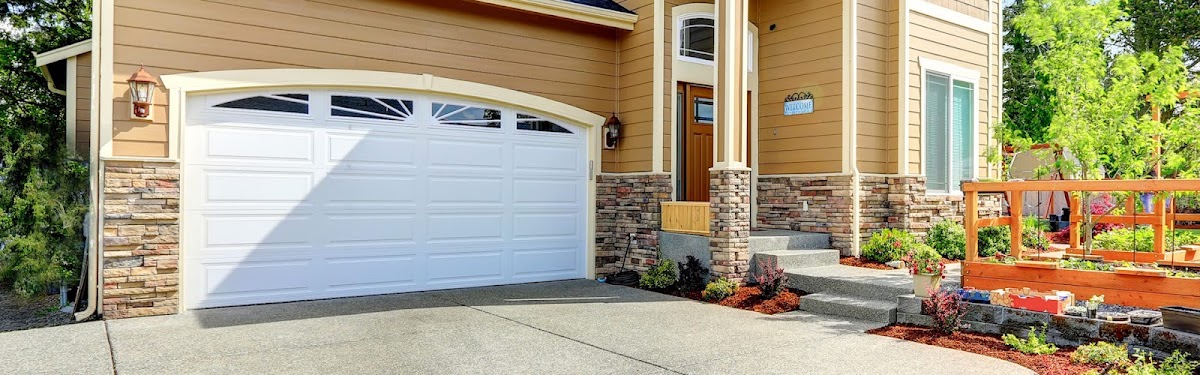 Close view of a cream garage door with stone accents on a Marysville home, serviced by Marysville Overhead Door Repair & Opener