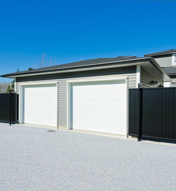 Single garage with white door, dusk shot with the porch light on